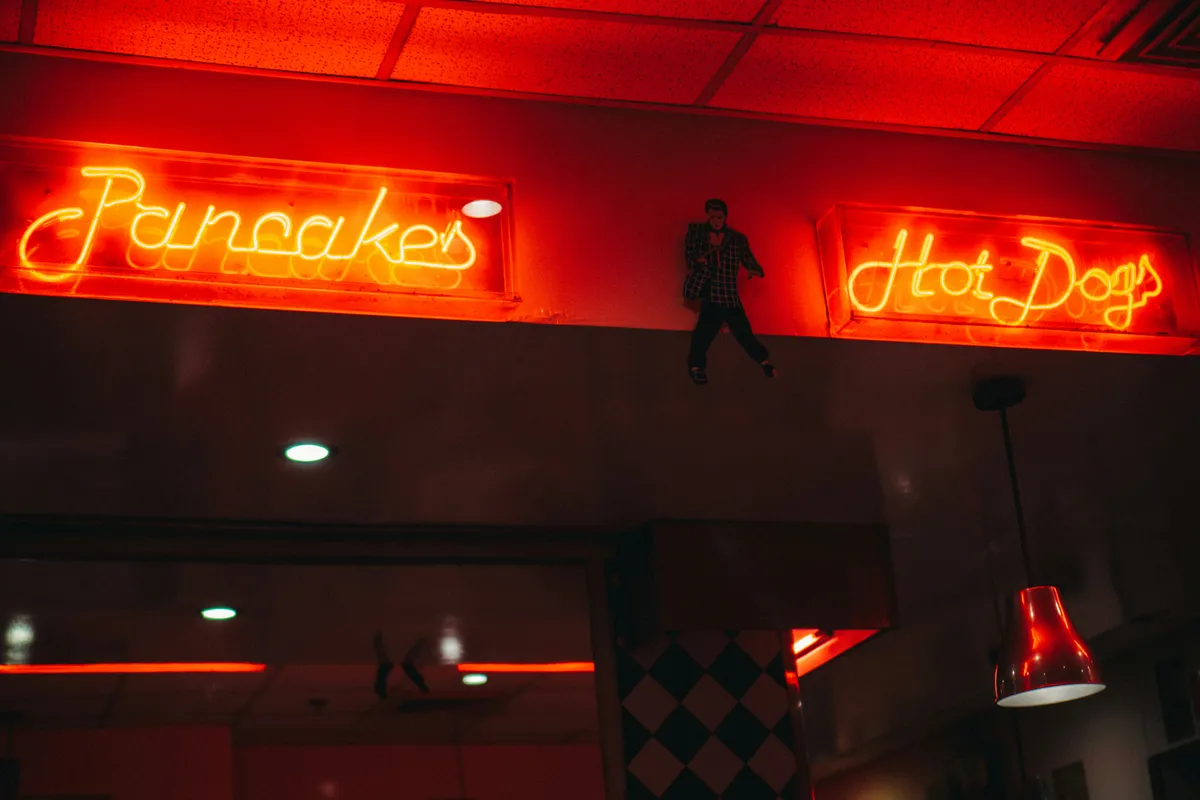 Yellow neon lettering glowing at full strength on a black night