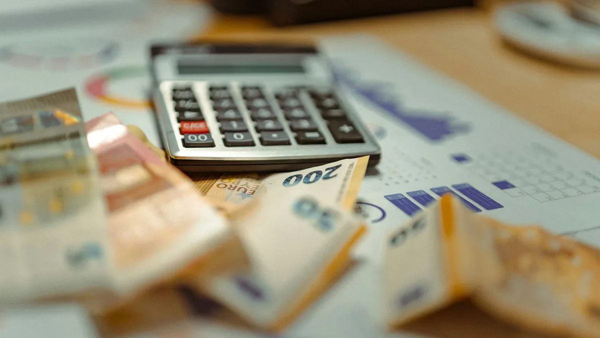 Calculator sitting on top of a pile of paper money