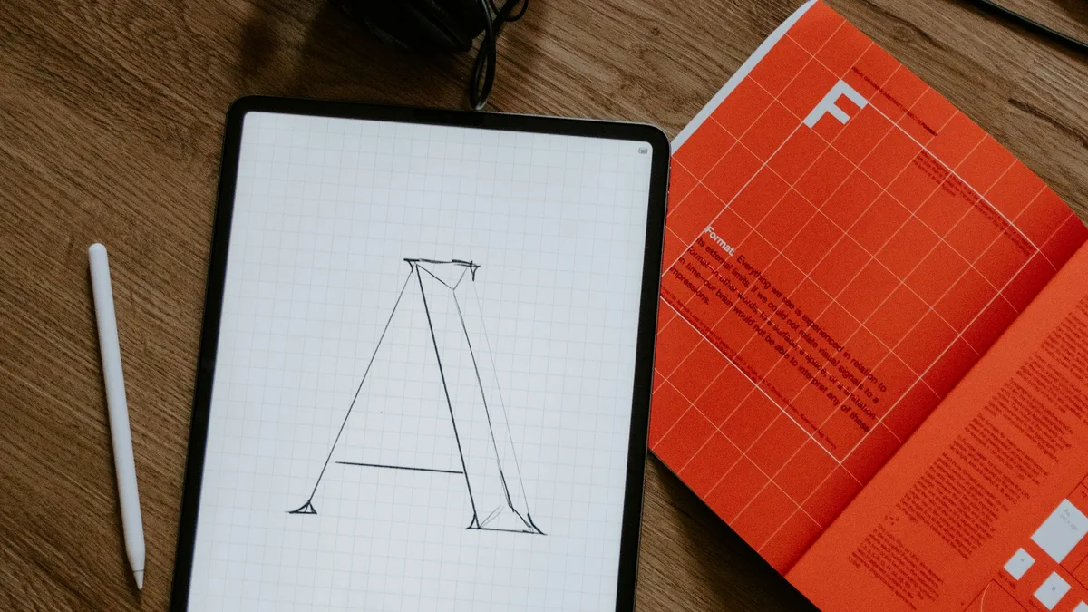 Handwritten notes and a pen on paper beside a laptop, representing a font audit workflow